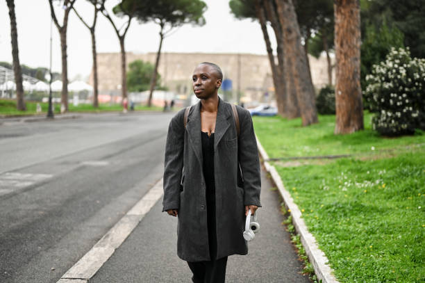 아침에 텅 빈 도시 거리를 걷는 양모 코트를 입은 젊은 여성. - haute couture audio 뉴스 사진 이미지