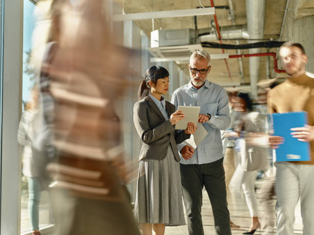 istock Diverse entrepreneurs using touchpad among colleagues in blurred motion at office. 2050249555