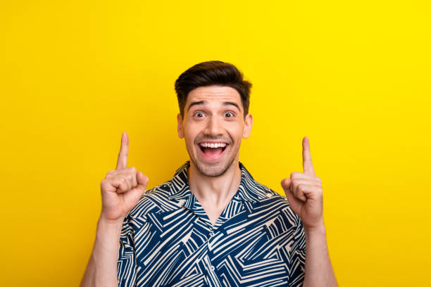 istock Photo of impressed ecstatic man with bristle dressed blue clothes indicating at poster empty space isolated on yellow color background 2050252238