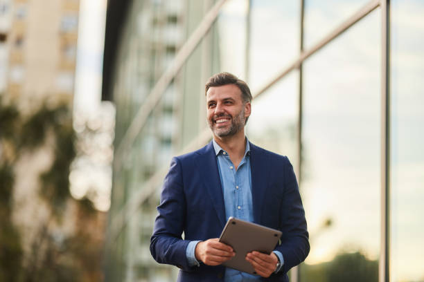 Happy businessman enjoying on the city street. Happy male entrepreneur day dreaming while holding laptop on the street. Copy space. pace yourself photos stock pictures, royalty-free photos & images