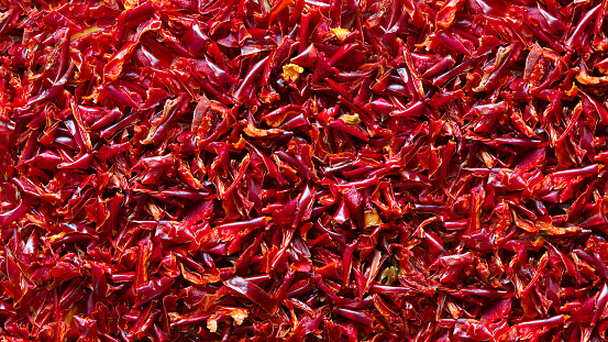 Red hot chili peppers drying. Close up of fresh dried chopped red hot chilli peppers. Background, texture of chillies.
