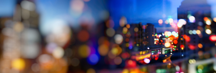 An abstract composition featuring a blurred cityscape at night, overlaid with a grid pattern that fades into the bokeh light effects, reflecting the complex network of a digital urban environment