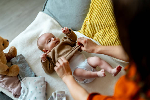 istock Happy loving mother changing her little daughters diapers 2050356105