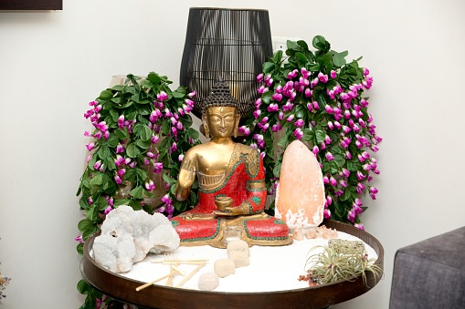 A table adorned with a Buddha statue and ornaments