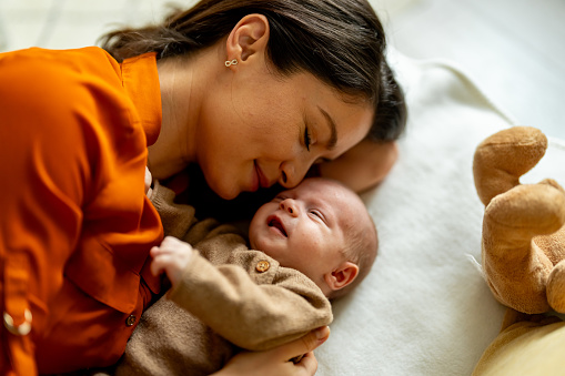 Young mother and baby napping at home