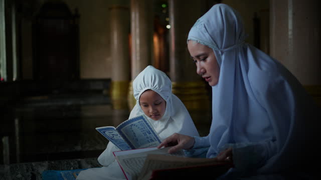 Muslim woman and young Asian Muslim girl praying in the mosque. of Ayutthaya Province, Thailand