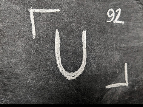 Химический элемент уран с серийным номером из таблицы Менделеева. Рисунок мелом.
