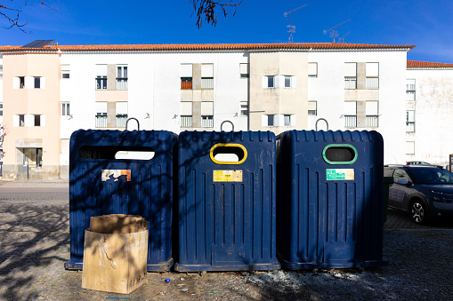 Urban sustainability: Colorful recycling bins in a city neighborhood, promoting eco-conscious living. Eco-friendly choices for a greener future.