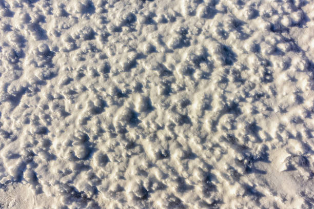 Texture of rough snow surface in sunlight blurred background, top view