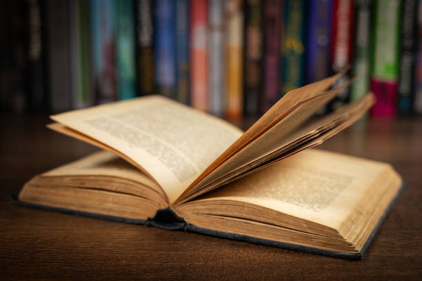 istock opened book, lying on the bookshelf in library 2050432024