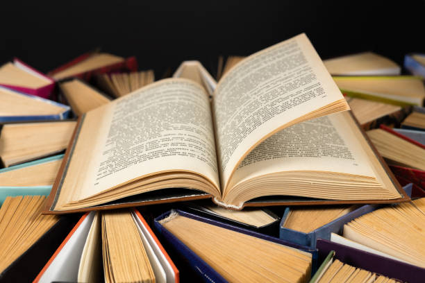 istock Open book and old books in library 2050433101