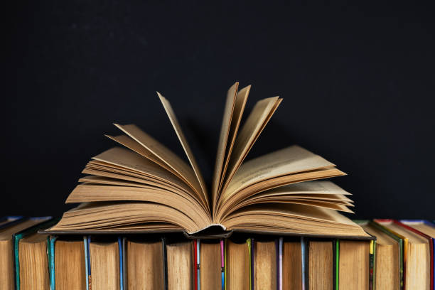 istock Open old book on books. Dark background 2050433115