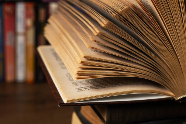 istock opened book, lying on the bookshelf in library 2050435798