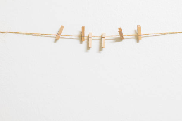 Clothespins on a rope on a white wall background with copy space