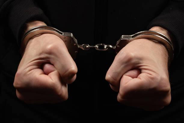 istock Male hands in handcuffs black background 2050444774