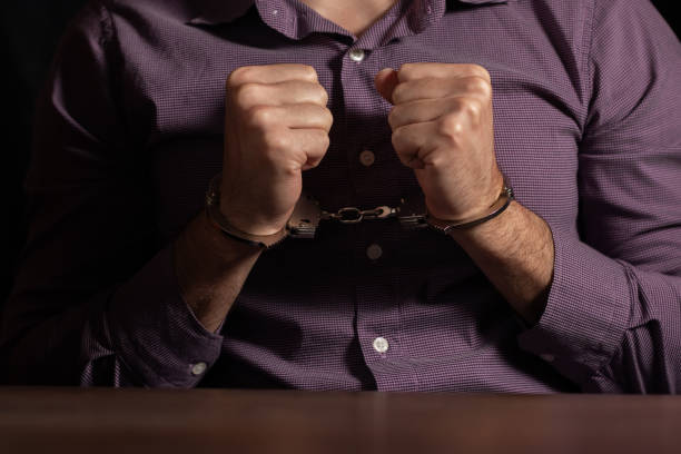 istock stressed out businessman hands bothered with handcuffs suffering at custody for concept of suspicious business 2050444786