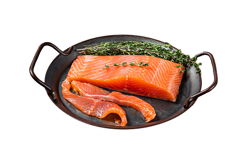 Slices of lightly salted salmon with thyme in a steel tray.  Isolated on white background. Top view