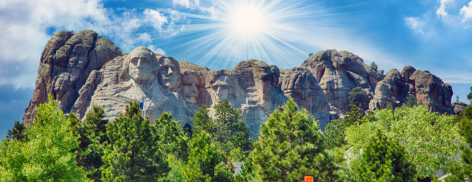 Mount Rushmore National Park in the Black Hills South Dakota during a warm sunrise with clear blue sky morning. High Dynamic Range. / Mount Rushmore National Park