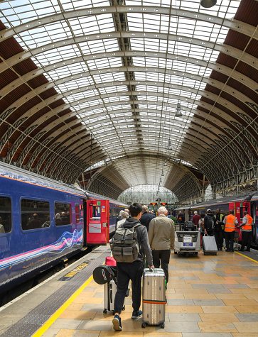 London, England, UK - 20 June 2018: Person wheeling a large suitcase along the platform after arriving at London Paddington railway station