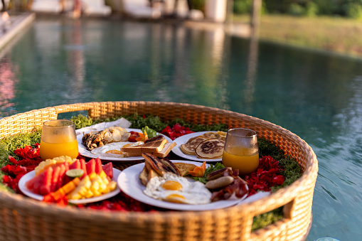 Breakfast serve on floating tray in the pool. Common breakfast serving style at villa