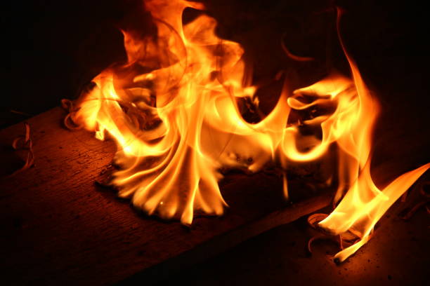 Unique and interesting orange, red and yellow flames of a small fire with  a plain black background.
