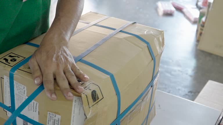 factory concept, Close up of workers' hands packing boxes of products.