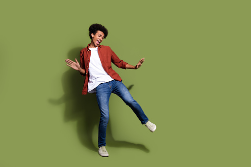 Full length photo of nice young male dancing boogie woogie wear trendy brown garment isolated on khaki color background.