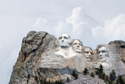 Photo of Mount Rushmore, South Dakota with trees lining the base of the mountain