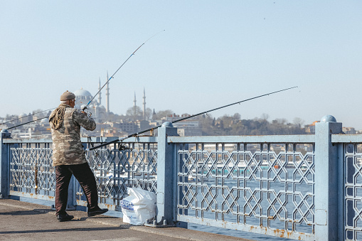 Istanbul, Turkey-February,22: People with fishing lines on Galata Bridge