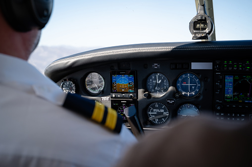 Pilot Helicopter Emergency Medical Service during flight above forest. Close-up of flight control inside cockpit.