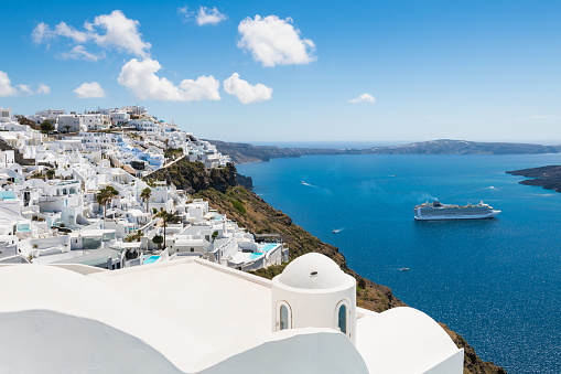Santorini island, Greece - April, 18, 2023: White architecture in Santorini island, Greece. Beautiful sea view in sunny day. Travel and vacation concept