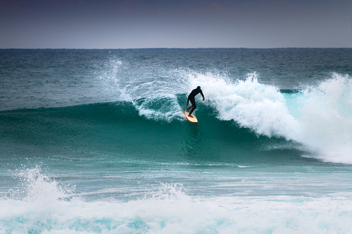 Nazare, Portugal - December, 19, 2023: Surfer riding big waves in Nazare, Portugal. Big waves of Atlantic ocean in winter season