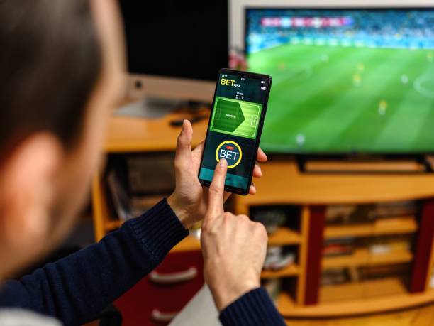 istock Young man using smart phone for sports betting. 2050545722