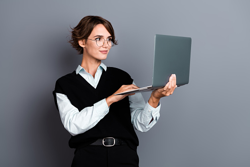 Photo of gorgeous dreamy woman wear stylish black clothes hold modern wireless device macbook isolated on grey color background