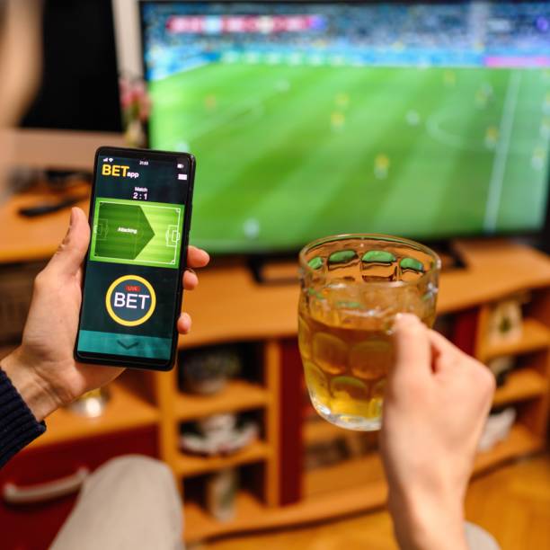 istock Young man using smart phone for sports betting. 2050557560