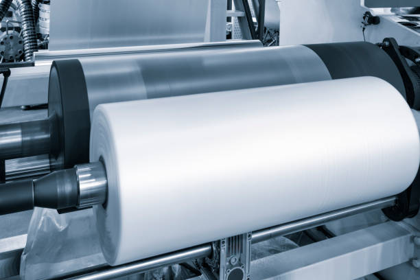 istock Automatic polyethylene plastic bag production machine with lighting effect. Close-up of the roller of the plastic bag production machine in the light blue scene. product packaging concept 2050562418