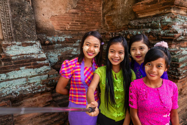 Young Burmese girl with thanaka face paint taking a selfie in the ancient temple of Bagan, Myanmar (Burma)