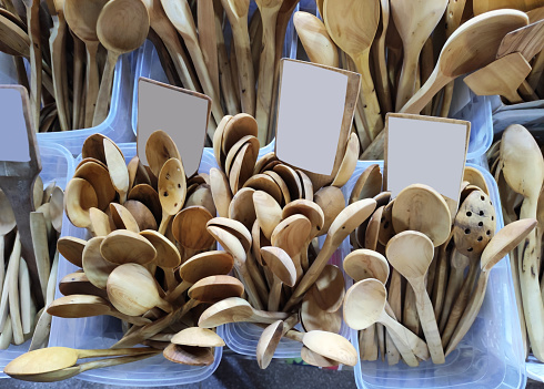 Wooden brown kitchen spoons for mixing food, on the shop a window