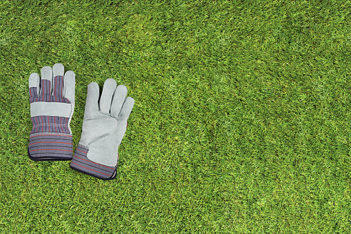Working or gardening gloves on a grass background