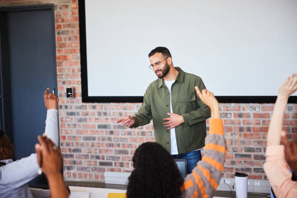 istock Smiling college teacher taking questions from students during a lecture 2050639398