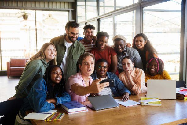 istock Smiling college students taking selfies with their teacher in a school cafeteria 2050653615
