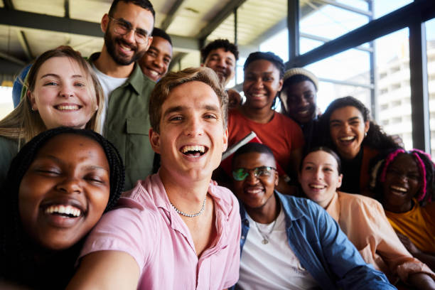 istock Laughing college students and their teacher taking selfies in a school cafeteria 2050656302