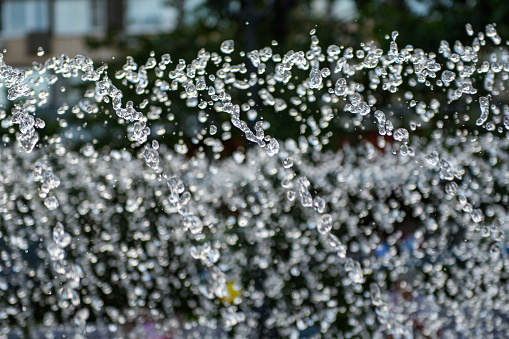 Outdoor fountain in hot weather. The drops froze in flight. Close-up.