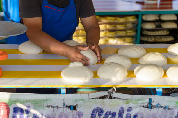 Baker preparing bread in a street bakery in a Mexican market.