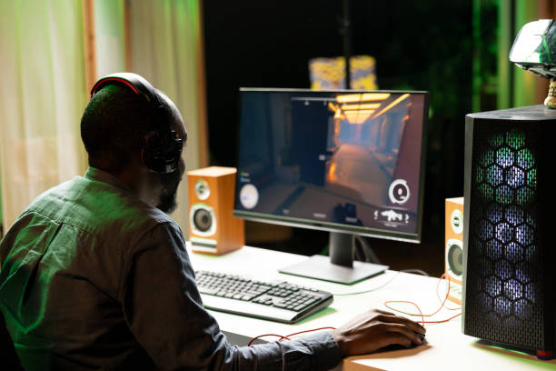 Man in dark living room playing science fiction videogame on gaming PC