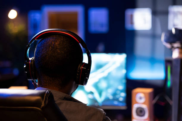istock Focus on man playing videogames on computer monitor in blurry background 2050665991