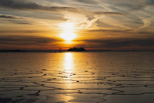 Seascape in winter at sunset. View from the shore of Viimsi, a ferry sailing on the frozen sea. High quality photo