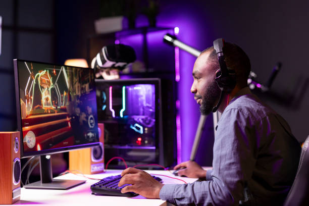 istock Man plays science fiction FPS videogame, chatting with friends using headphones 2050671494