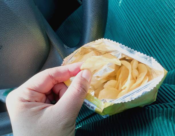 istock Eating potato chips in the bag on car 2050671599