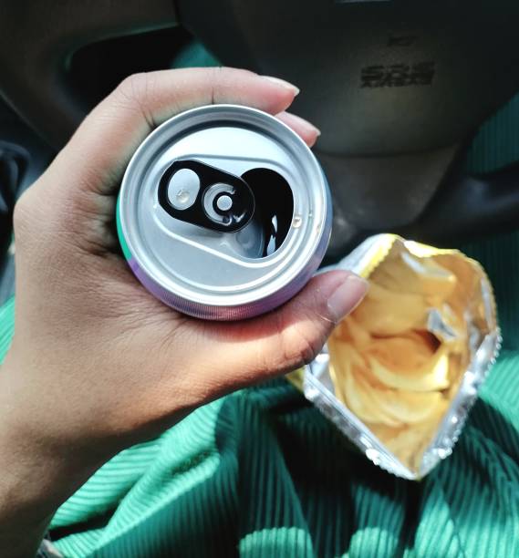 Woman drinking cola on hand and potato chips